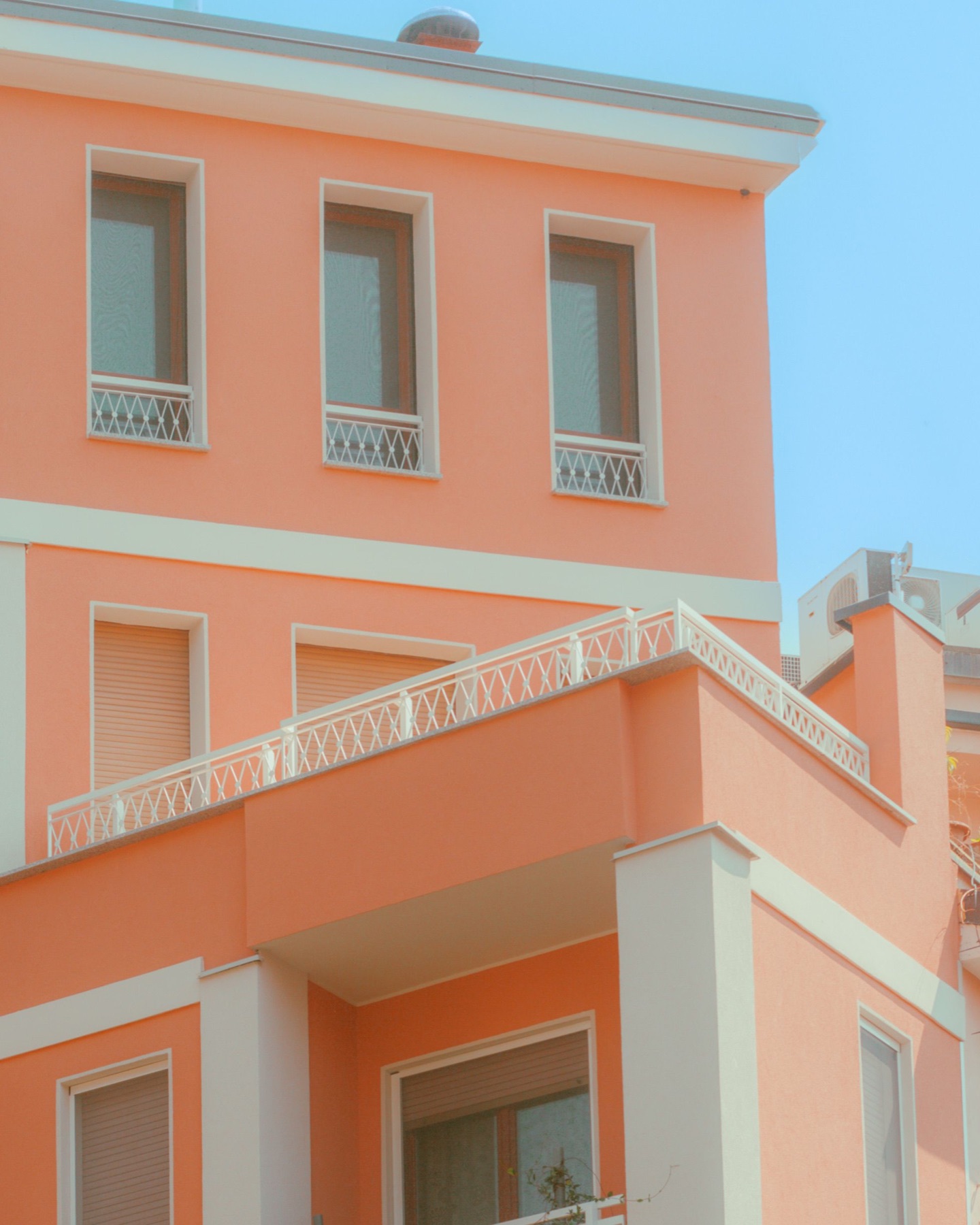 Facciata simmetrica color pastello con porte e finestre ad arco