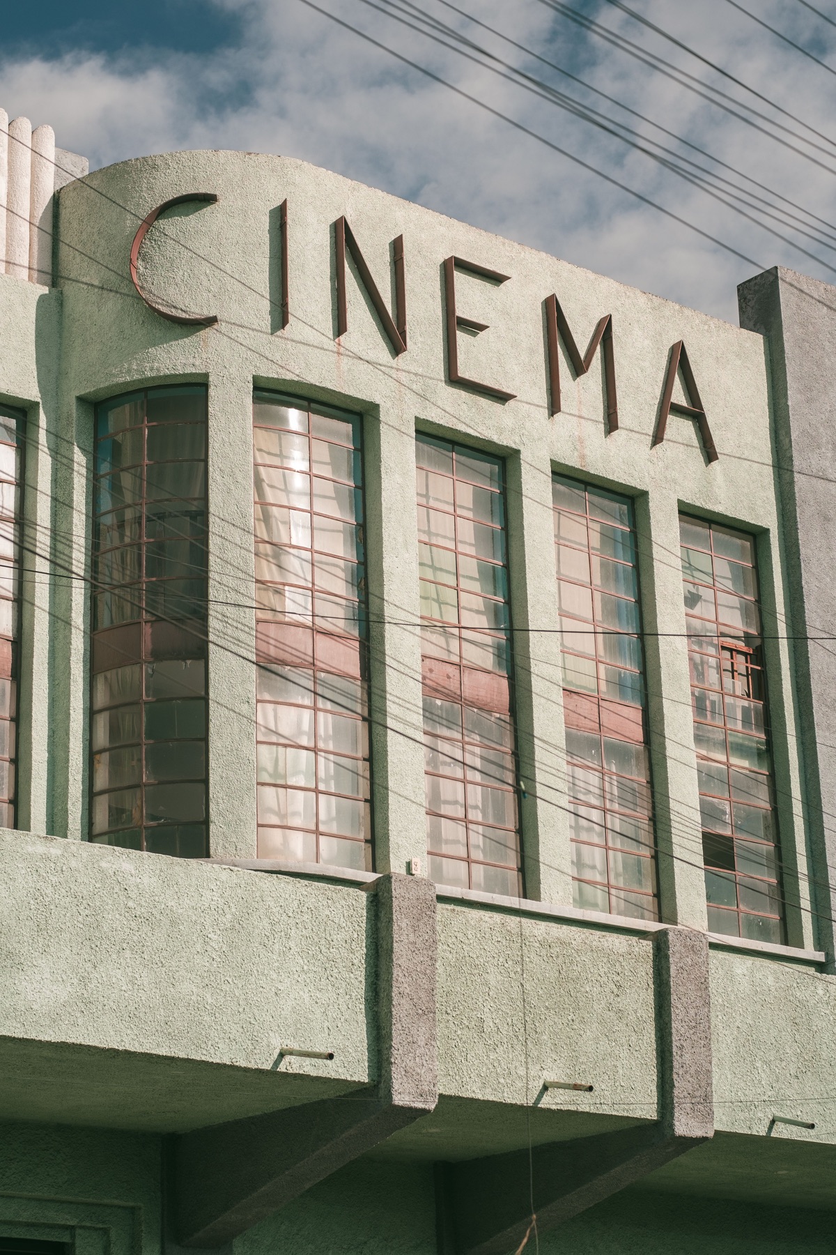 Cinema Art Déco color pastello con insegna verticale