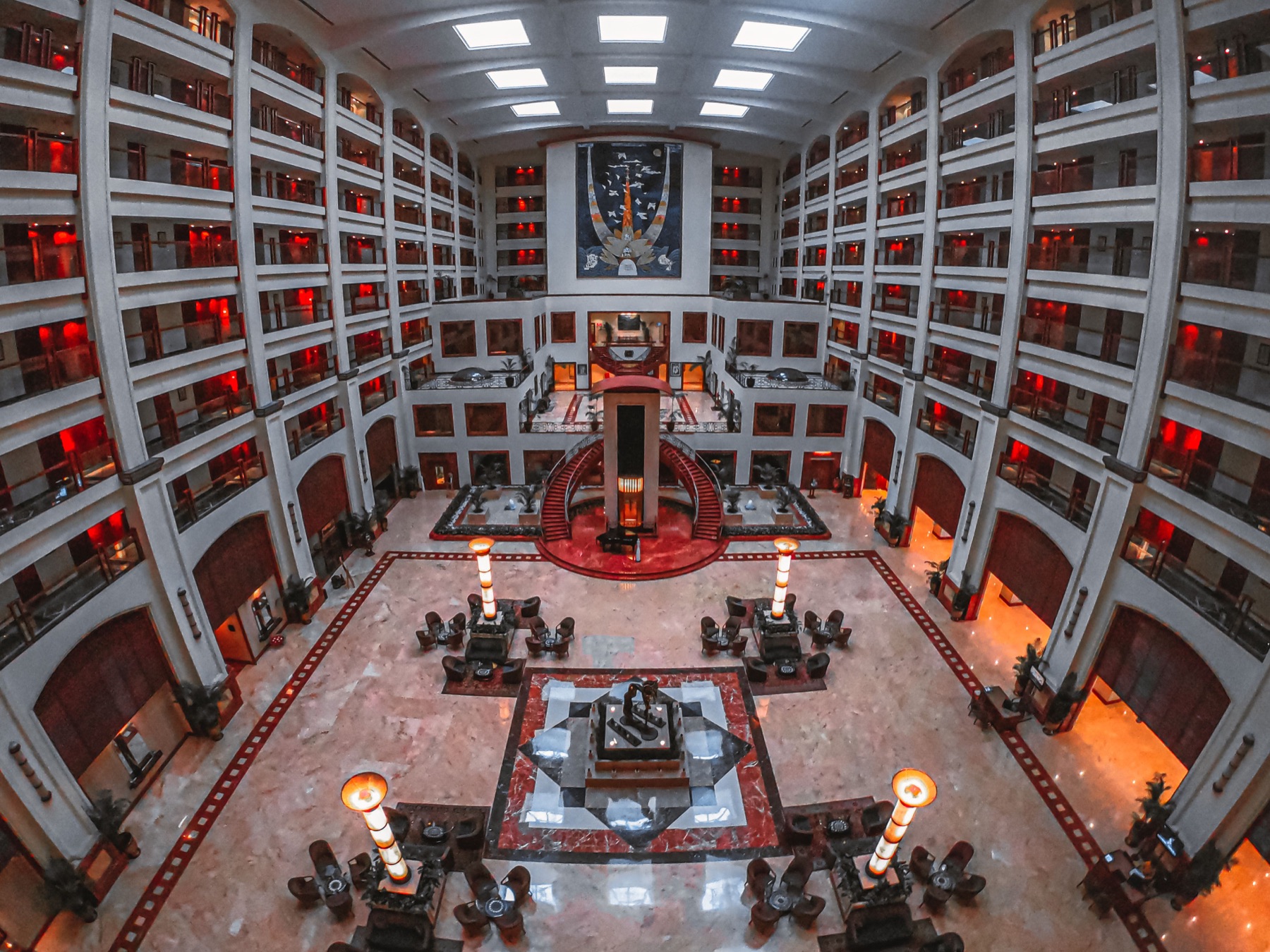 Lobby d’hotel simmetrica con grandi finestre e arredi eleganti